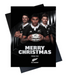 Christmas card with rugby players holding a ball, featuring 'Merry Christmas from the All Blacks'.