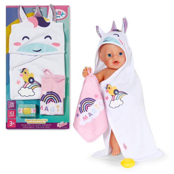 Baby doll with unicorn-themed towel and packaging on a white background