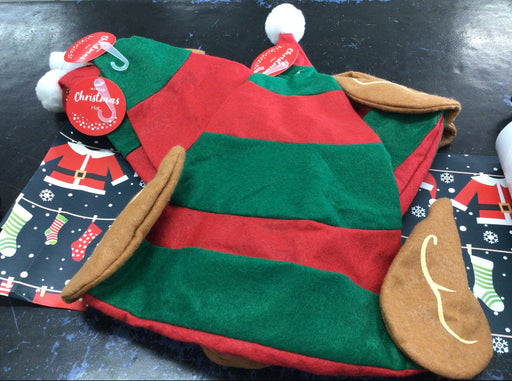 Red and green dog sweater with brown ears on a dark surface