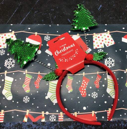 Red Christmas-themed headband with green trees on a festive background