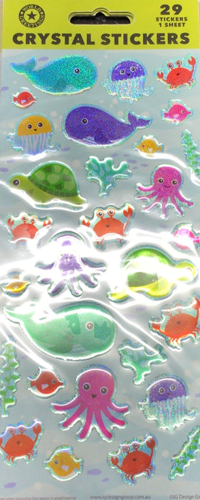 Pack of crystal stickers with sea-themed designs on a dark surface next to a keyboard.