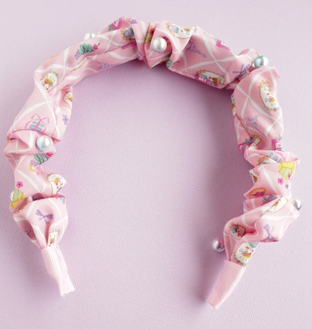 Pink headband with floral pattern on a light purple background