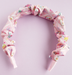 Pink headband with floral pattern on a light purple background