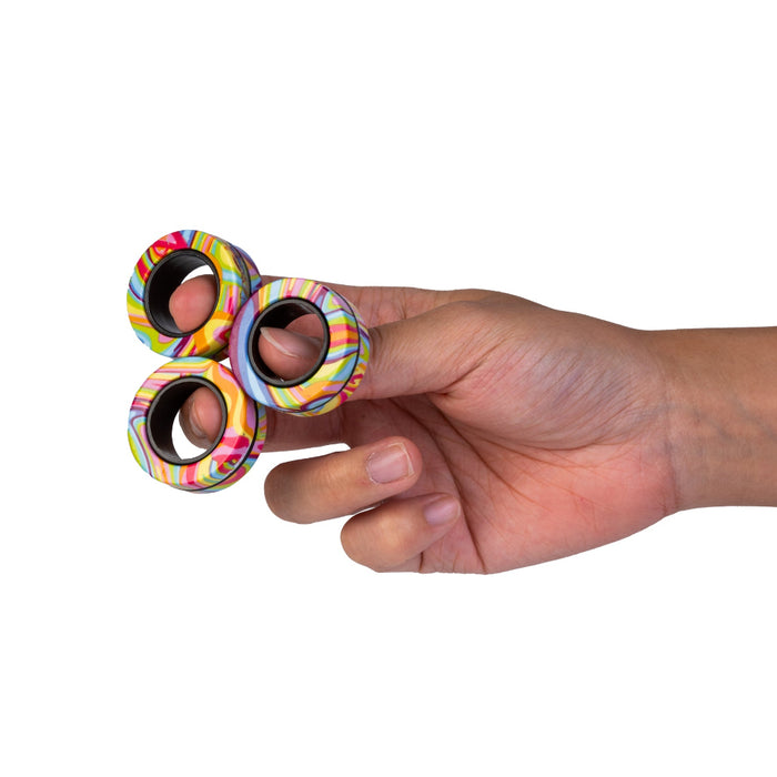 Hand holding a colorful fidget spinner against a white background