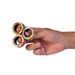 Hand holding a colorful fidget spinner against a white background