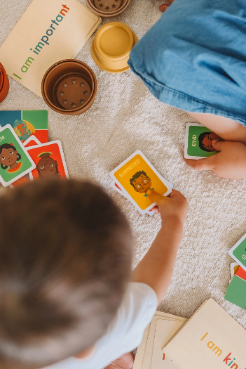 Child playing with educational cards on a carpeted floor