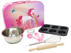 Children's baking set with pink unicorn-themed tin, mixing bowl, measuring cups, whisk, and rolling pin on a white background.