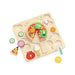 Wooden toy pizza with various food-shaped pieces on a white background