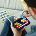 Person holding a transparent container with colorful star-shaped objects on a couch.