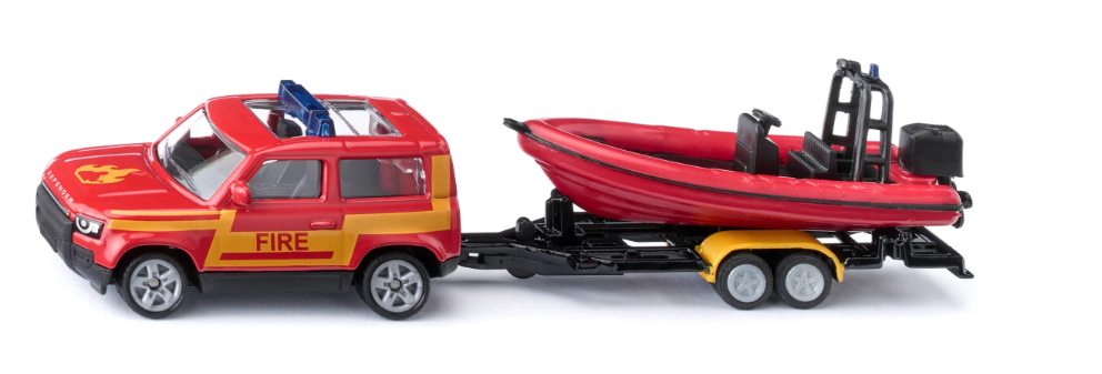 Model fire truck with a trailer carrying a red boat on a white background