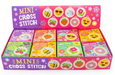 Box of mini cross stitch kits with colorful designs on a white background