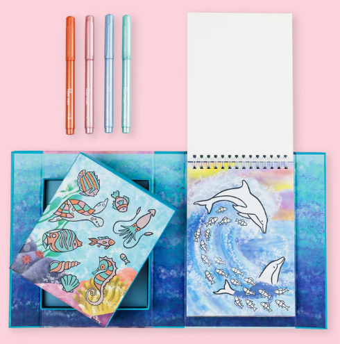 Colorful stationery set with pens and notebooks on a pink background